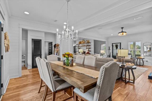 dining room featuring crown molding, light hardwood / wood-style flooring, and a chandelier