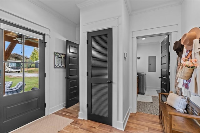 entryway featuring ornamental molding, electric panel, and light hardwood / wood-style floors