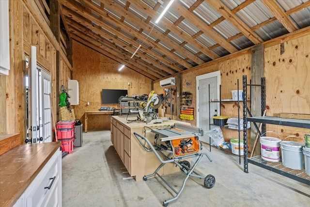 misc room with vaulted ceiling, a workshop area, and an AC wall unit