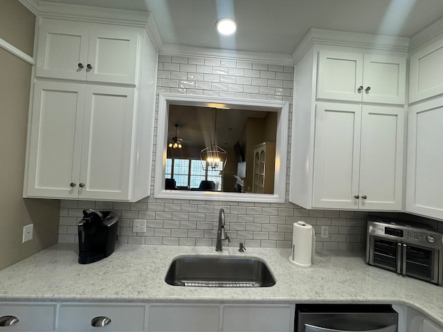 kitchen featuring white cabinets, backsplash, ceiling fan, and sink