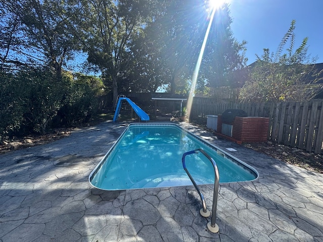 view of swimming pool featuring a patio area and a water slide