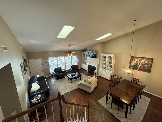 living room with ceiling fan, dark wood-type flooring, and vaulted ceiling