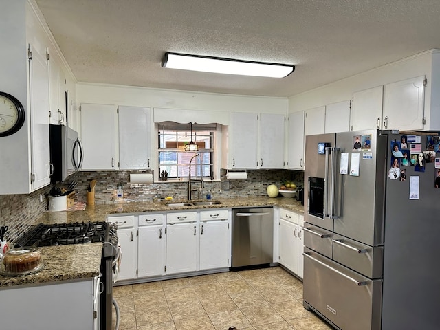 kitchen with sink, white cabinetry, a textured ceiling, stone countertops, and appliances with stainless steel finishes