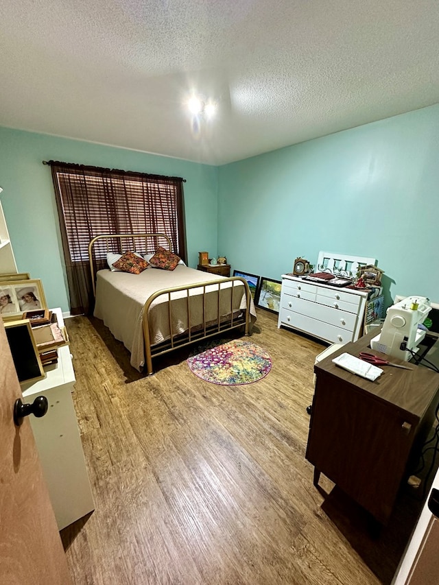 bedroom featuring a textured ceiling and light hardwood / wood-style flooring