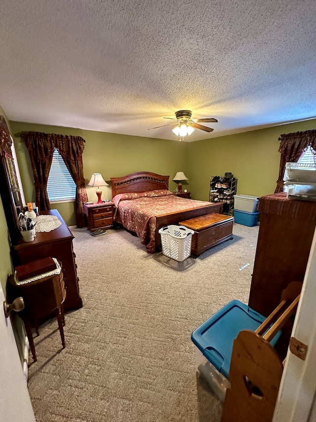 carpeted bedroom with a textured ceiling and ceiling fan