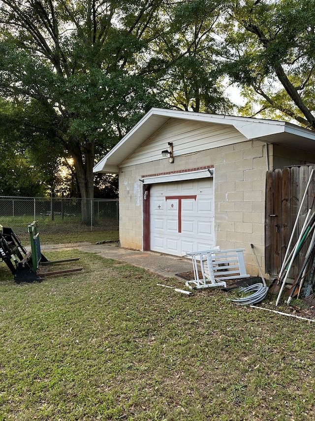 view of outdoor structure featuring a garage and a lawn