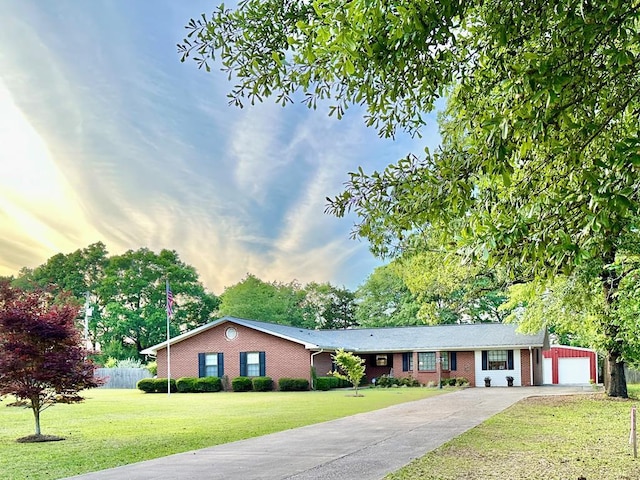 ranch-style house featuring a garage, an outdoor structure, and a lawn