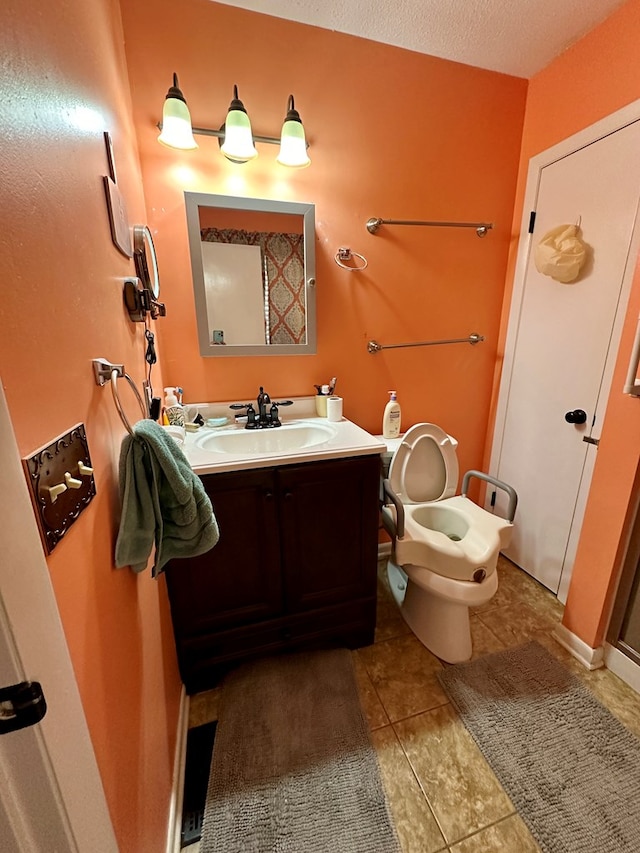 bathroom featuring a textured ceiling, vanity, tile patterned floors, and toilet