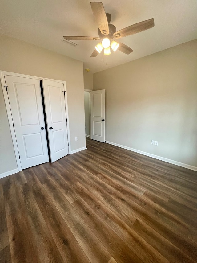 unfurnished bedroom featuring dark hardwood / wood-style flooring, a closet, and ceiling fan