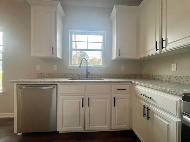 kitchen with light stone countertops, stainless steel appliances, white cabinetry, and sink