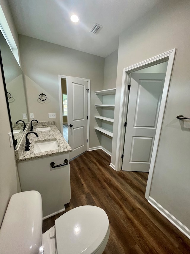 bathroom featuring toilet, vanity, and hardwood / wood-style flooring