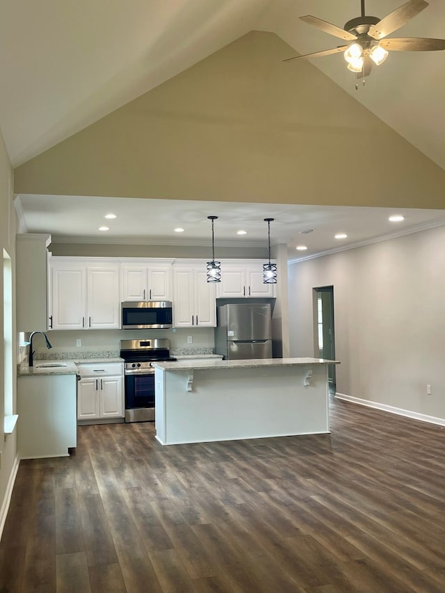 kitchen with stainless steel appliances, high vaulted ceiling, white cabinets, dark hardwood / wood-style floors, and hanging light fixtures