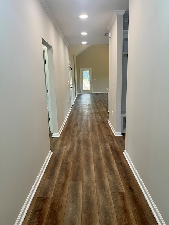 hallway featuring dark hardwood / wood-style floors, vaulted ceiling, and crown molding