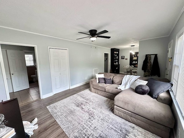 305 Highland Ave, Ozark, AL 36360 - living area featuring a ceiling fan, wood finished floors, a textured ceiling, baseboards, and ornamental molding