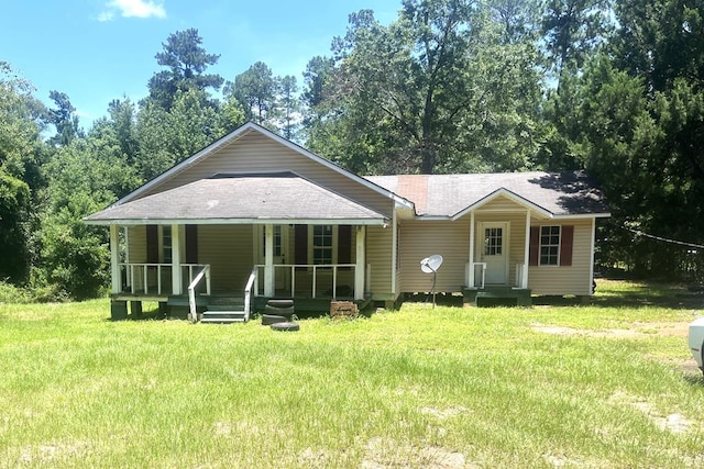 7 November Rd, Ashford, AL 36312 - view of front facade with a porch, roof with shingles, a front yard, and view of wooded area