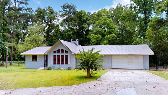 391 Hatton Rd, Dothan, AL 36301 - view of front of home featuring a front yard, a chimney, concrete driveway, a metal roof, and view of scattered trees
