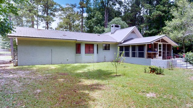 391 Hatton Rd, Dothan, AL 36301 - rear view of property with a sunroom, a yard, brick siding, and a metal roof
