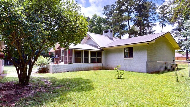 391 Hatton Rd, Dothan, AL 36301 - rear view of house with a sunroom, brick siding, a chimney, and a metal roof