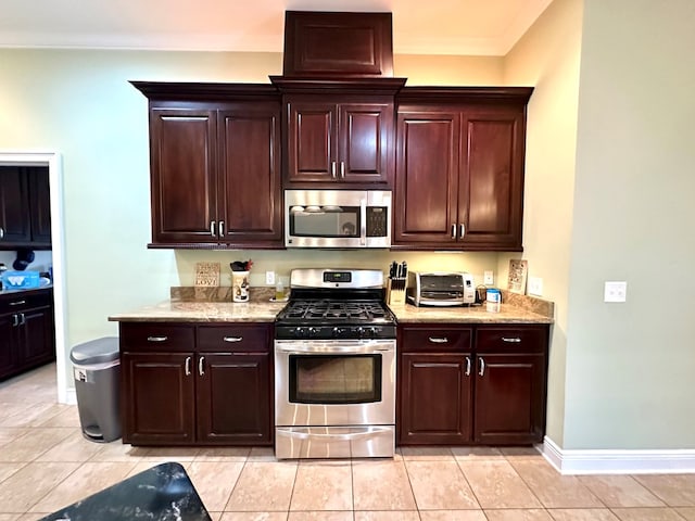 202 Frisco Ln, Enterprise, AL 36330 - kitchen with dark brown cabinets, baseboards, light stone counters, appliances with stainless steel finishes, and light tile patterned floors