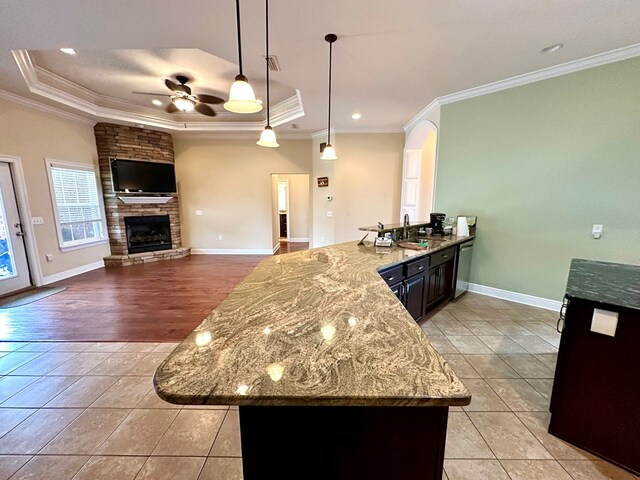 kitchen with stainless steel appliances, decorative light fixtures, an island with sink, and a breakfast bar area