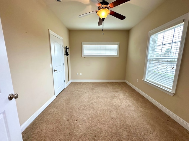 spare room with ceiling fan and light carpet