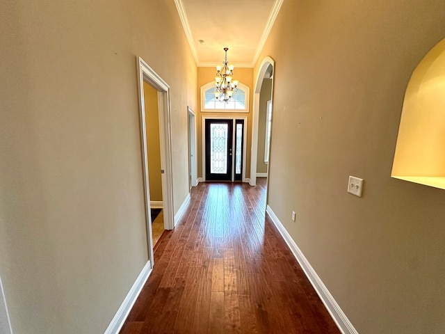 doorway to outside featuring ornamental molding, dark hardwood / wood-style floors, and a chandelier