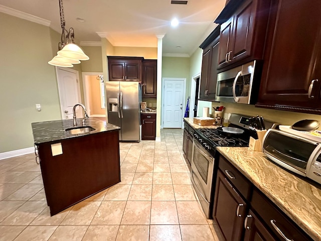 kitchen with sink, hanging light fixtures, appliances with stainless steel finishes, ornamental molding, and an island with sink