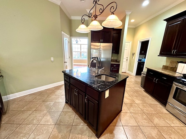 kitchen featuring appliances with stainless steel finishes, pendant lighting, sink, dark stone counters, and a center island with sink