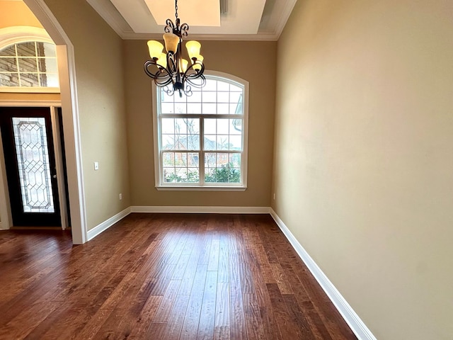 entrance foyer featuring an inviting chandelier, dark wood-type flooring, and ornamental molding