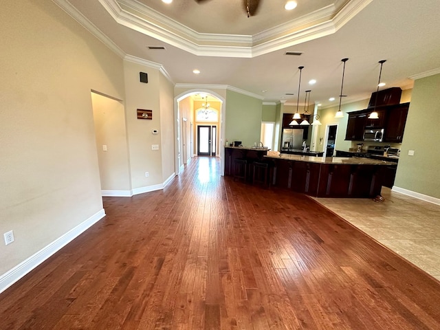 202 Frisco Ln, Enterprise, AL 36330 - kitchen with a tray ceiling, arched walkways, dark wood-style floors, ornamental molding, and stainless steel appliances