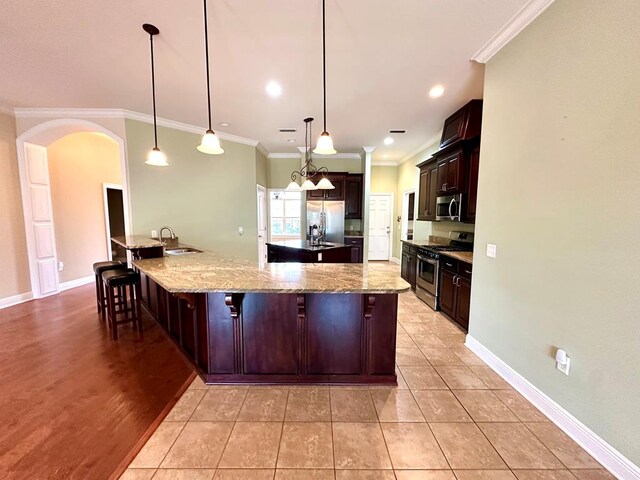 kitchen featuring crown molding, light tile patterned floors, a tray ceiling, and decorative light fixtures