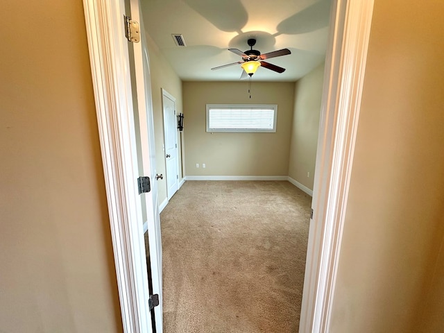 spare room with ceiling fan and light carpet