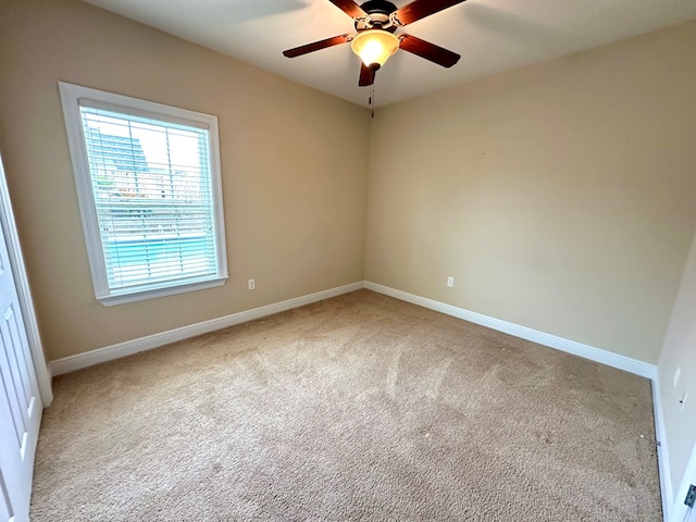 carpeted spare room with ceiling fan