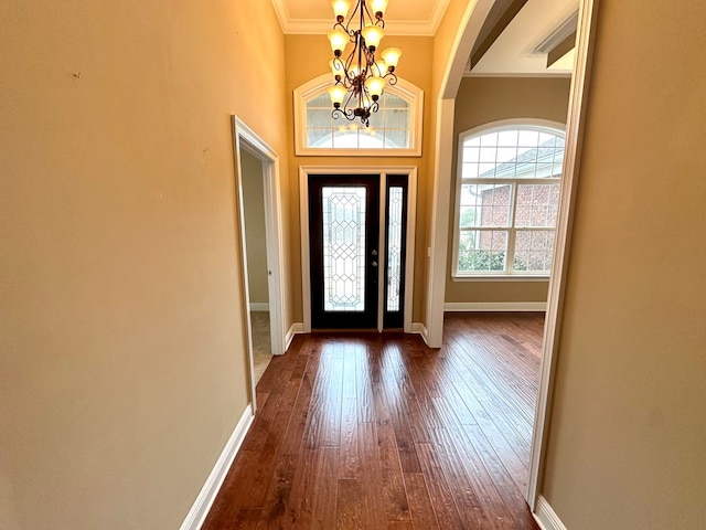 entryway featuring ornamental molding, dark hardwood / wood-style flooring, and a chandelier