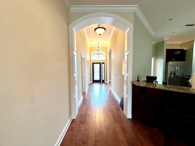 hall with crown molding, dark hardwood / wood-style floors, and an inviting chandelier