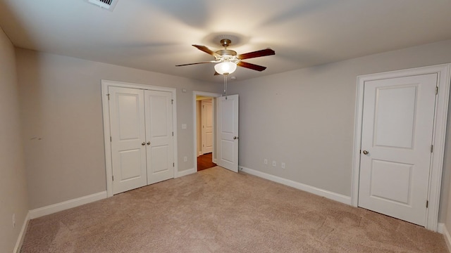 unfurnished bedroom featuring ceiling fan, light carpet, and a closet