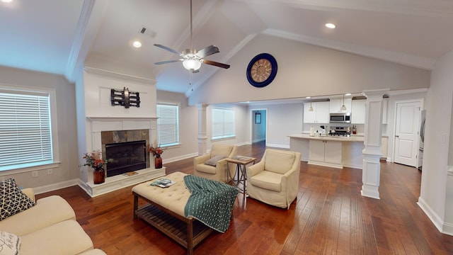 living room featuring ornate columns, dark hardwood / wood-style flooring, high vaulted ceiling, and a tiled fireplace