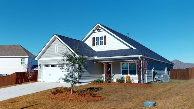 view of front of house with central air condition unit, a front lawn, and a garage