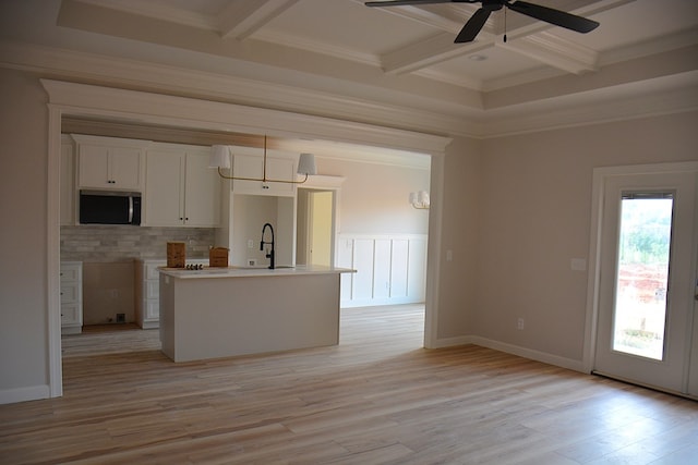 110 Mikala Ct, Enterprise, AL 36330 - kitchen featuring coffered ceiling, stainless steel microwave, light wood finished floors, beam ceiling, and white cabinets
