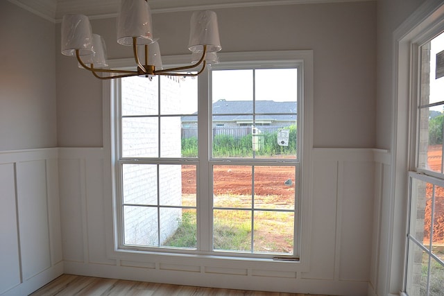 110 Mikala Ct, Enterprise, AL 36330 - detailed view of a chandelier, a decorative wall, a wainscoted wall, wood finished floors, and crown molding