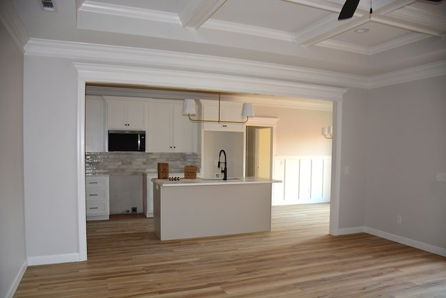 110 Mikala Ct, Enterprise, AL 36330 - kitchen featuring stainless steel microwave, backsplash, white cabinets, light wood-type flooring, and coffered ceiling