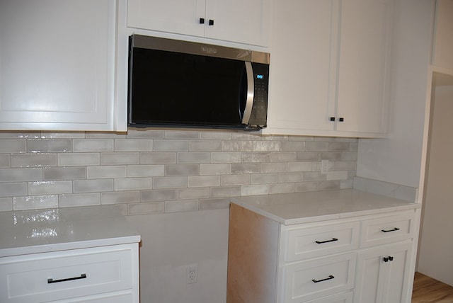 110 Mikala Ct, Enterprise, AL 36330 - kitchen featuring stainless steel microwave, light countertops, tasteful backsplash, and white cabinets