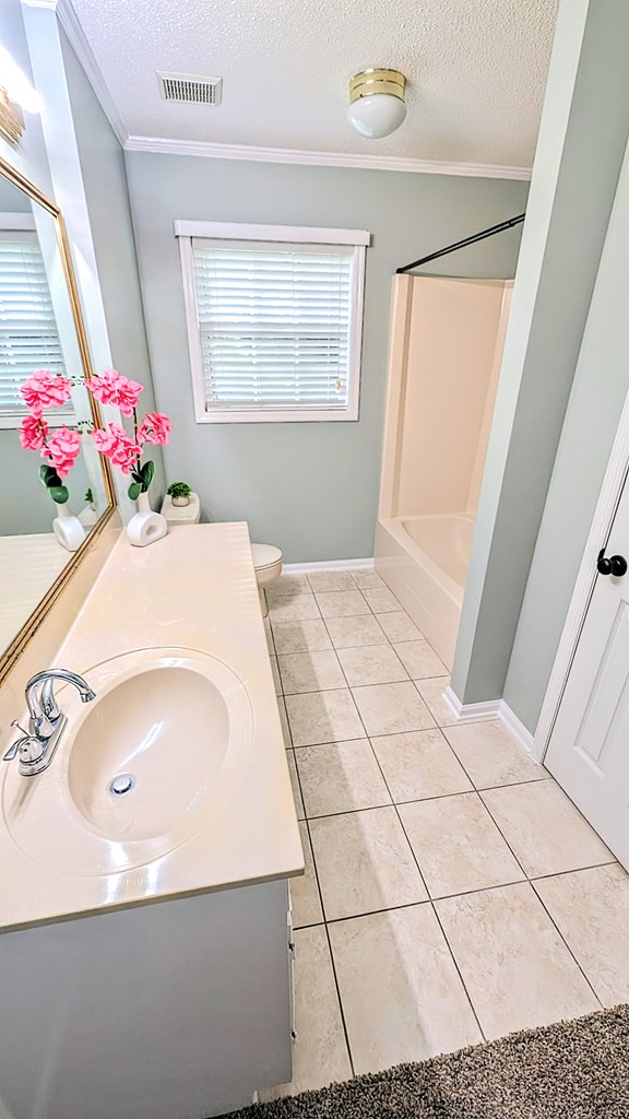5 Walford Pl, Dothan, AL 36301 - full bath featuring ornamental molding, vanity, a textured ceiling, shower / washtub combination, and tile patterned flooring