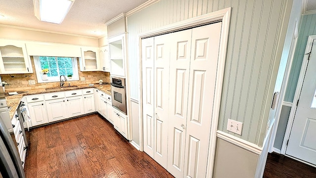5 Walford Pl, Dothan, AL 36301 - kitchen featuring oven, ornamental molding, dark wood-type flooring, decorative backsplash, and light stone countertops