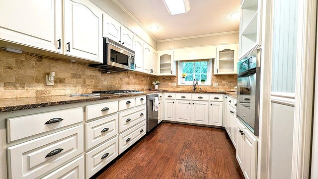 5 Walford Pl, Dothan, AL 36301 - kitchen featuring stainless steel appliances, crown molding, dark stone counters, dark wood-type flooring, and white cabinets
