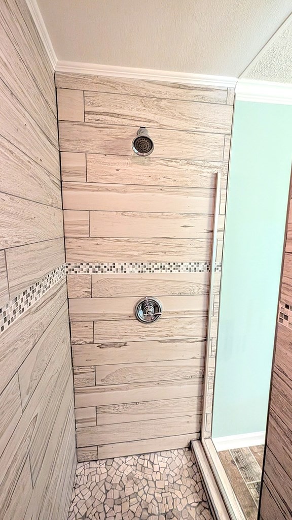 5 Walford Pl, Dothan, AL 36301 - bathroom with crown molding, a tile shower, and wooden walls