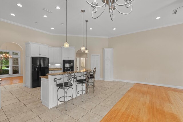 707 Edinburgh Way, Dothan, AL 36305 - kitchen with arched walkways, a notable chandelier, light tile patterned floors, and black appliances