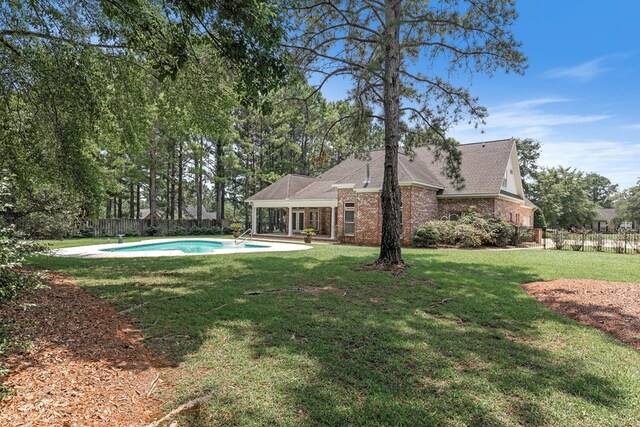 707 Edinburgh Way, Dothan, AL 36305 - exterior space with fence, a fenced in pool, a shingled roof, brick siding, and a lawn