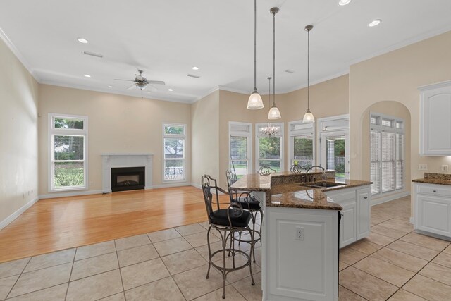 707 Edinburgh Way, Dothan, AL 36305 - kitchen featuring a ceiling fan, a fireplace, a breakfast bar area, a sink, and light tile patterned floors