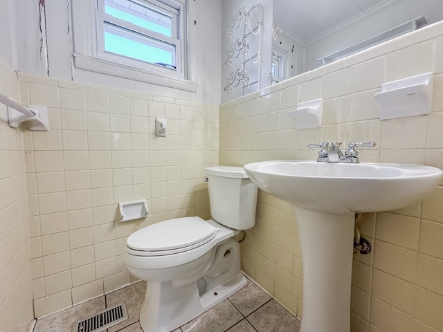 bathroom with tile patterned flooring, toilet, visible vents, tile walls, and ornamental molding